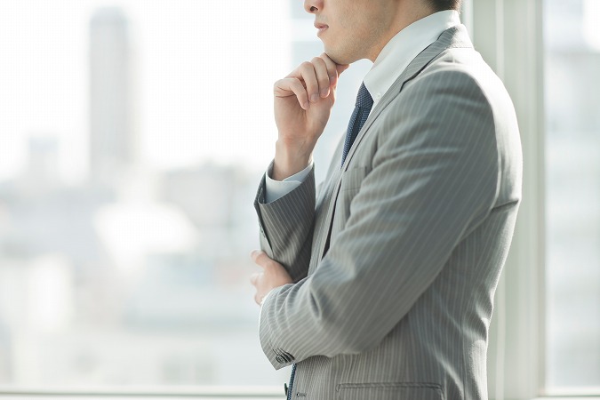 悩む男性グレーのスーツ